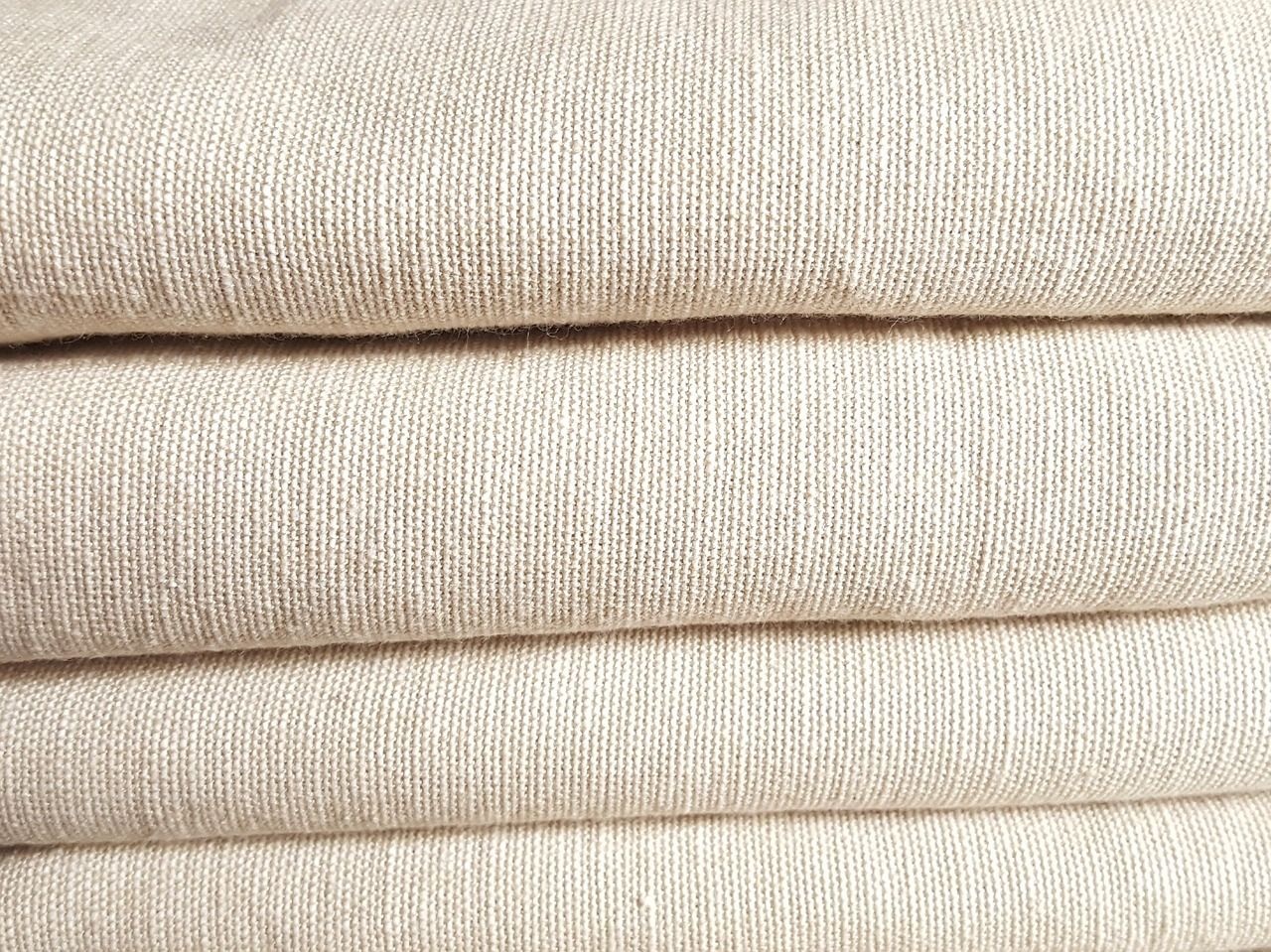 Folded cream-coloured woven fabric, showing its texture